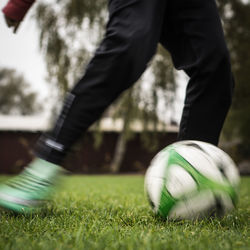 Low section of man playing soccer on field