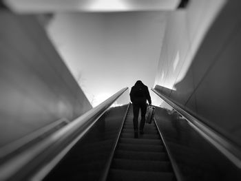 Rear view of man walking on staircase in tunnel