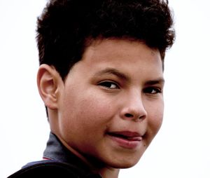 Close-up portrait of teenage boy against white background