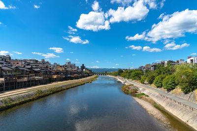 River amidst buildings in city against sky