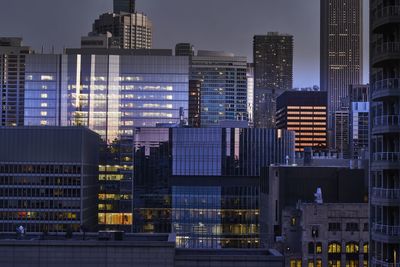 Modern buildings in city against sky at night