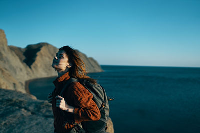 Woman standing in sea against sky