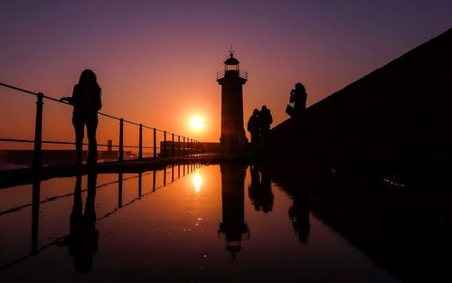 Silhouette of people in water at sunset