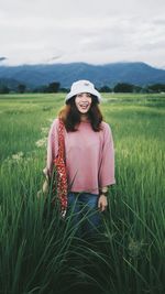 Woman standing on field against sky