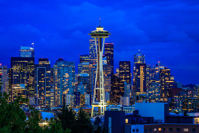 Illuminated cityscape against sky at night