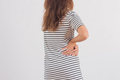 Rear view of woman standing against white background