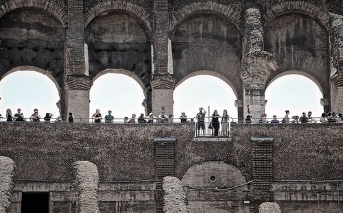 Low angle view of tourists visiting coliseum