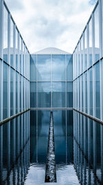 Pond with glass structure against sky