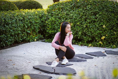 Portrait of young woman exercising on road