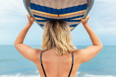 Rear view of woman wearing hat at beach