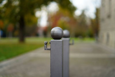 Close-up of metal on footpath in park