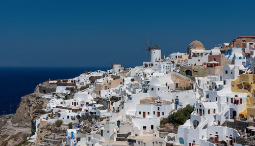 High angle view of buildings in city against blue sky