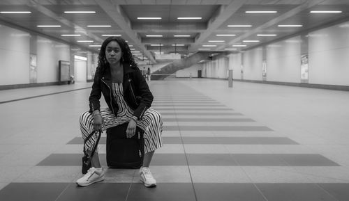 Side view of woman sitting at railroad station platform