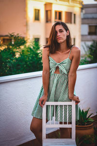 Beautiful young woman standing in balcony