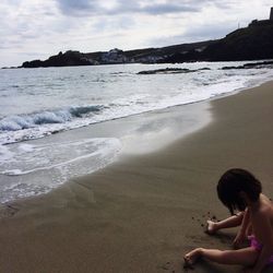 Boy on beach against sky