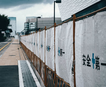 Text on wall by building against sky