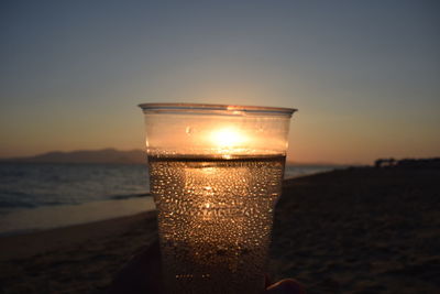 Close-up of glass of water at sunset