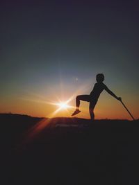 Silhouette person standing on land against sky during sunset