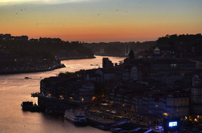 View of city at waterfront during sunset