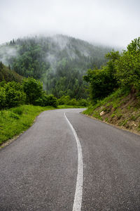 Road amidst trees against sky