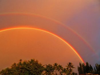 Low angle view of rainbow against sky during sunset