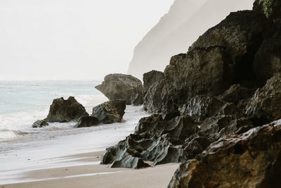 Rocks on beach against sky