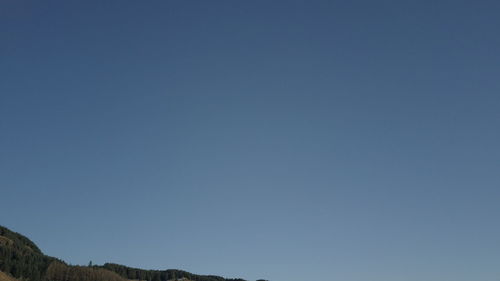 Low angle view of mountain against clear blue sky