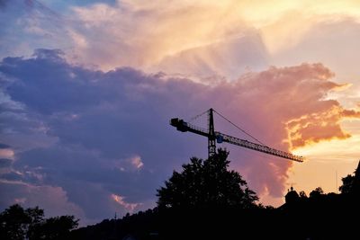 Low angle view of silhouette crane against sky during sunset