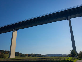Low angle view of bridge against clear blue sky