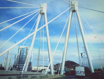 Suspension bridge against cloudy sky