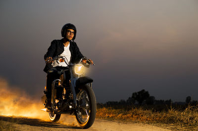 Portrait of man riding motorcycle on road