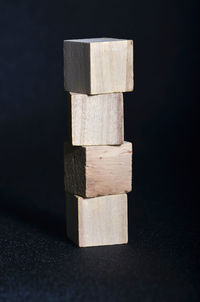 Close-up of stacked wooden blocks on black table