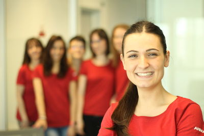 Portrait of smiling young woman against friends