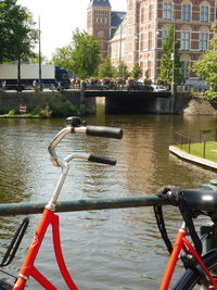 Bicycle on railing by river in city