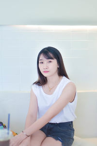 Portrait of young woman sitting on mirror