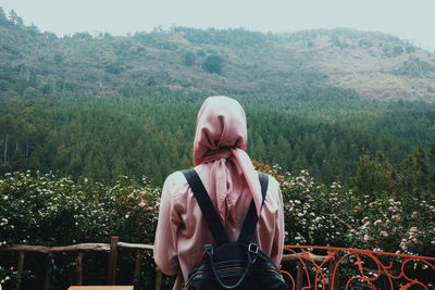 Rear view of woman in headscarf standing against mountain