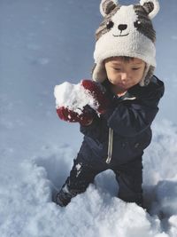 Boy playing with snow during winter