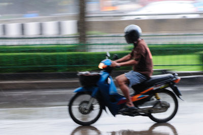 Man riding motorcycle on wet street