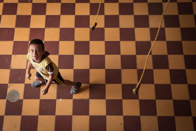 High angle view of man sitting on tiled floor