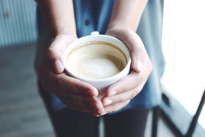 Midsection of woman holding coffee