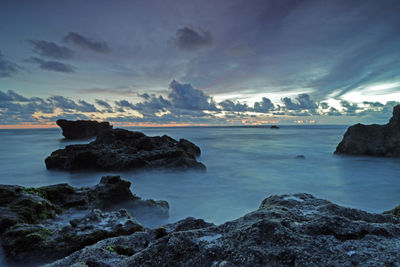 Rocks on sea shore against sky