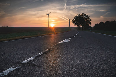 Surface level of road against sky at sunset