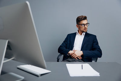 Portrait of businessman using laptop at office