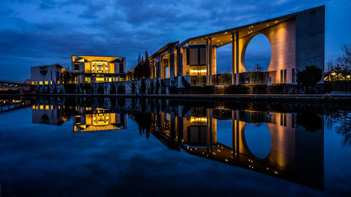 German chancellery building reflection in spree river against sky at night