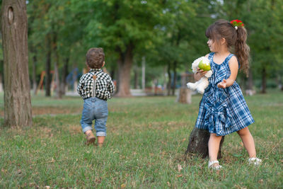 Full length of siblings playing on field at park