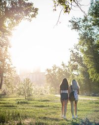 Rear view of couple walking against plants