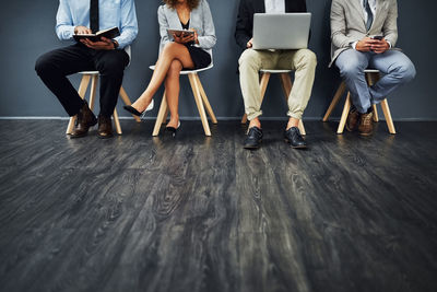 Low section of people walking on hardwood floor