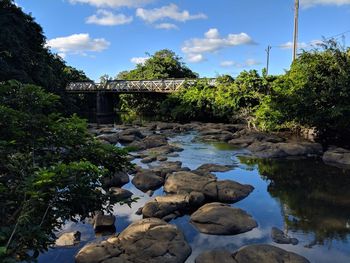 Rocks by lake against sky