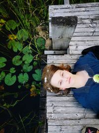 Portrait of woman standing against wooden wall