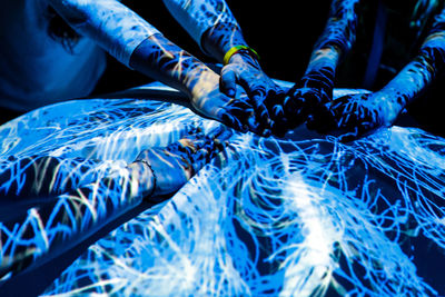 Close-up of hands on blue light